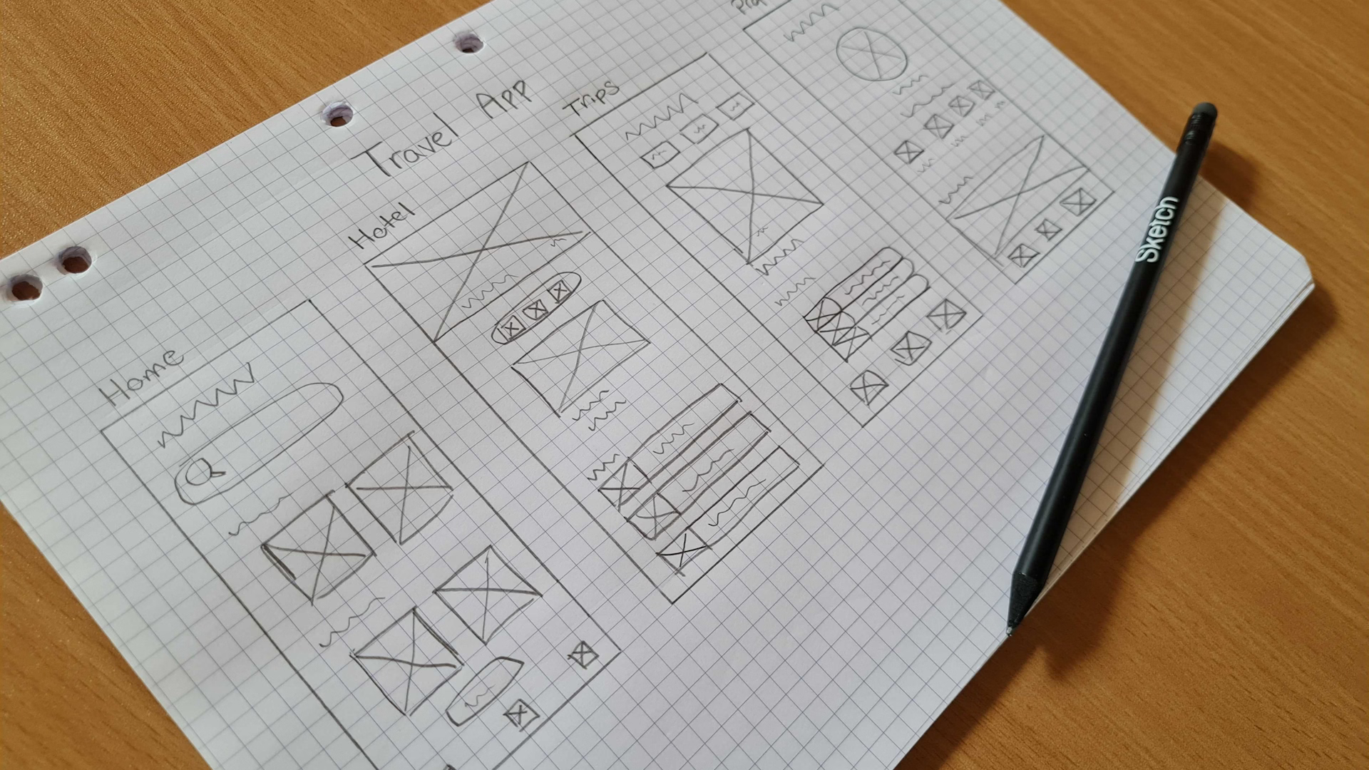 Hand-drawn mobile app wireframing sketches on graph paper with a pencil