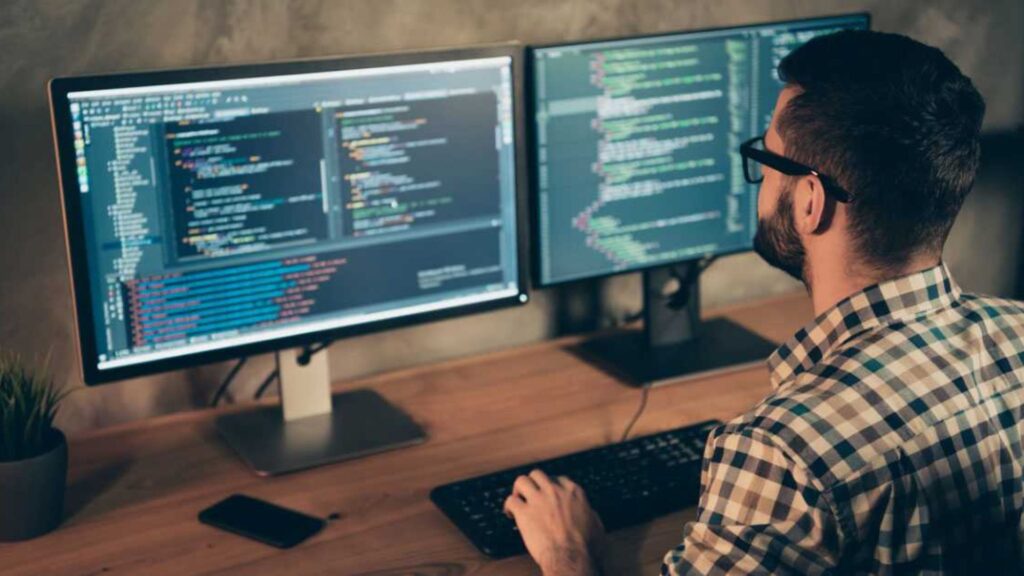a man using tools for web development on his computers