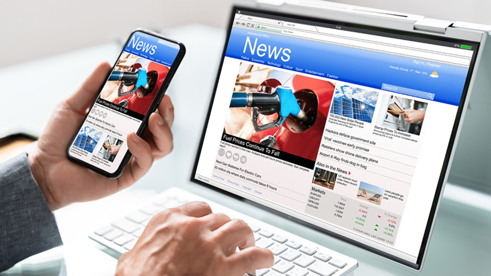 Person accessing online news on a responsive website via laptop and smartphone